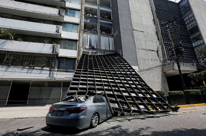 A damaged car is seen outside a building after an earthquake in Mexico City