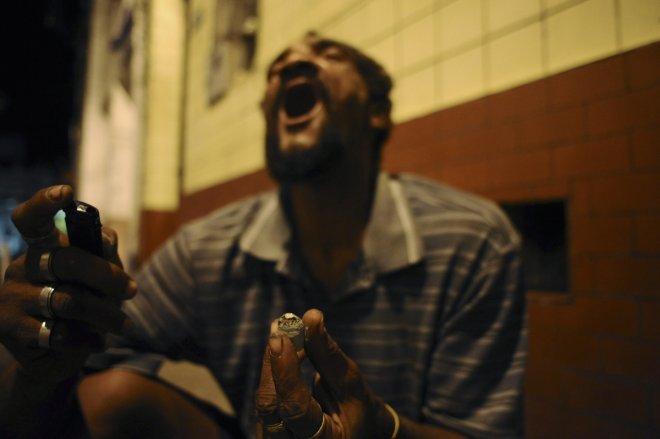 A drug user consumes crack in the old center of Salvador da Bahia March 19, 2012. Many Brazilian cities now have their own 