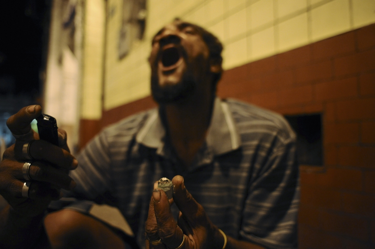 A drug user consumes crack in the old center of Salvador da Bahia March 19, 2012. Many Brazilian cities now have their own "cracklands," areas of the city where swarms of crack users have converted entire neighborhoods into nocturnal encampments doubling 