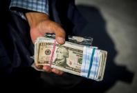 Money changer holds U.S. dollar bills at Grand Bazaar in the center of Tehran Money changer holds U.S. dollar bills at Grand Bazaar in the center of Tehran