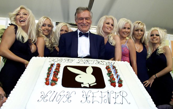 Hugh Hefner (C) Playboy founder and Editor-in-Chief, displays a giant birthday cake