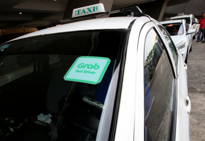 Grab taxi queues while waiting for passengers at the Ninoy Aquino International Airport (NAIA) in the metro Manila, Philippines, July 22, 2016. This logo has been updated and is no longer in use.