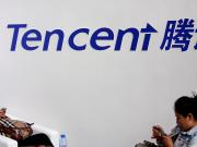 Visitors use their smartphones underneath the logo of Tencent at the Global Mobile Internet Conference in Beijing May 6, 2014. REUTERS/Kim Kyung-Hoon/File Photo