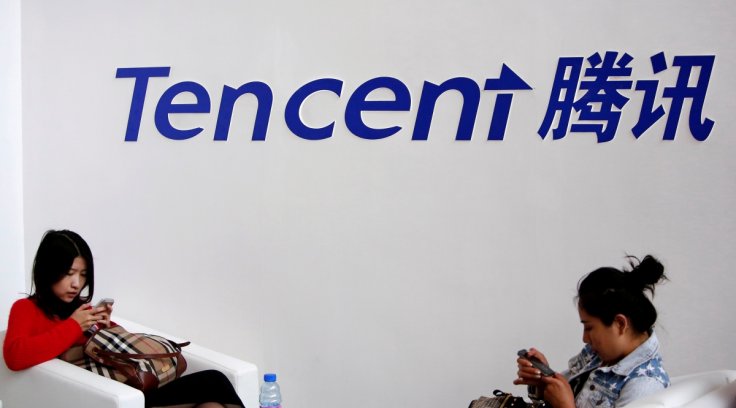 Visitors use their smartphones underneath the logo of Tencent at the Global Mobile Internet Conference in Beijing May 6, 2014. REUTERS/Kim Kyung-Hoon/File Photo