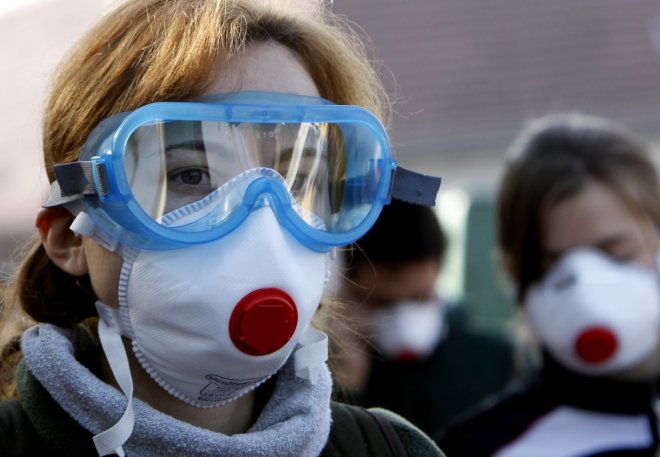 Schoolchildren wear protective goggles and masks to protect against toxic dust from dried mud in the flooded village of Devecser, 150 km (93.2 miles) west of Budapest October 13, 2010. Prime Minister Viktor Orban visited the area around an alumina plant w