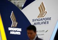 A man walks past a Singapore Airlines signage at Changi Airport in Singapore