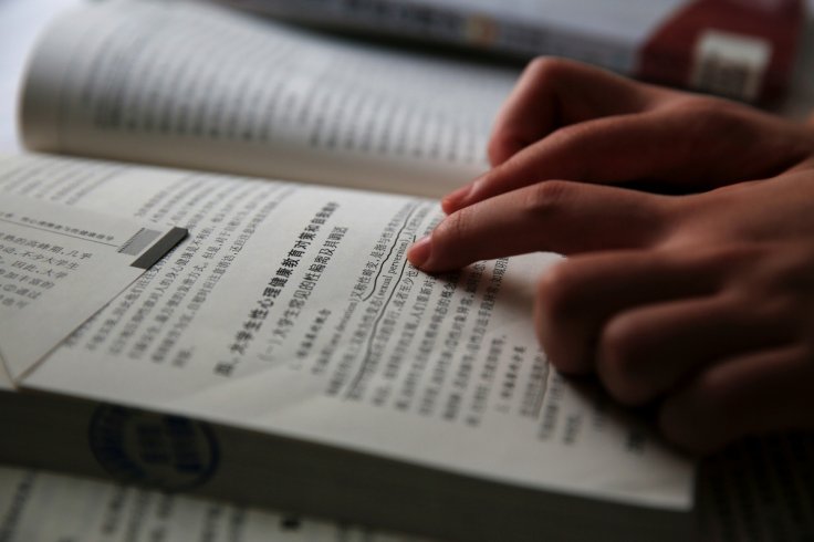 Qiu Bai, a Chinese student who lodged a suit against the Ministry of Education over school textbooks describing homosexuality as a mental disorder, shows the textbooks she refers to before going to the court in Beijing, China