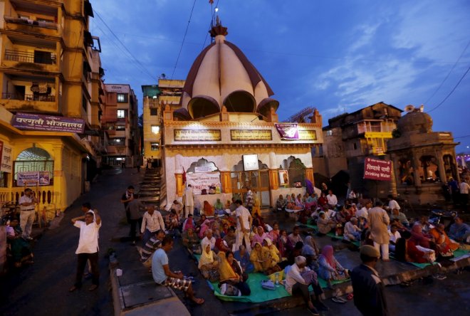 Devotees pray outside a temple on the banks of Godavari river during Kumbh Mela in Nashik, India