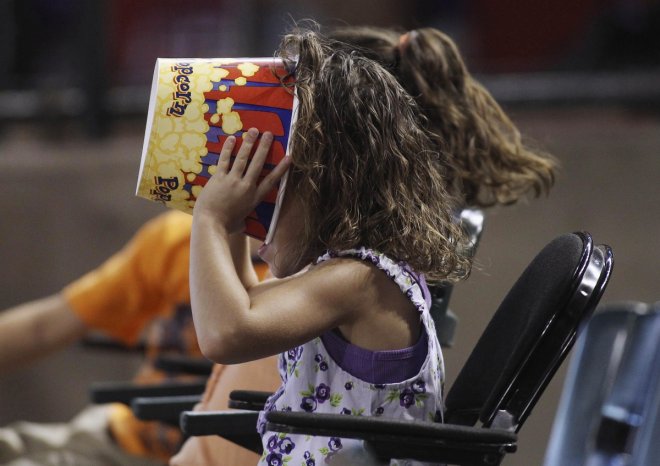 A young baseball fan makes sure there's not a kernel of popcorn left as she watches the Chicago Cubs play the Arizona Diamondbacks during their MLB National League baseball game in Phoenix, Arizona, June 24, 2012.