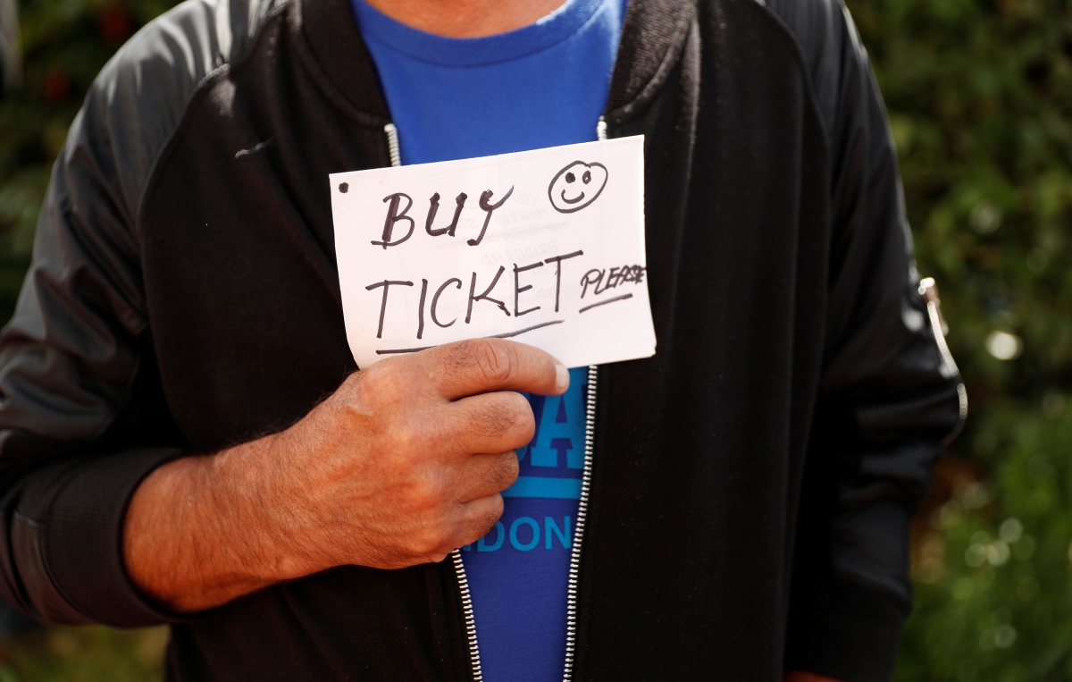 Football Soccer - Premier League - Swansea City vs Manchester United - Swansea, Britain - August 19, 2017 A man holds a sign looking for a ticket before the match Action Images via Reuters