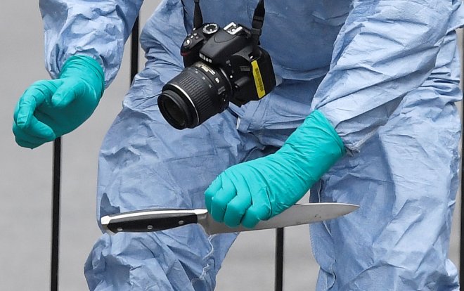 A forensic investigator recovers a knife after man was arrested on Whitehall in Westminster