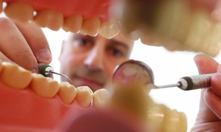 Dentist Sevan Arzuyan poses for an illustration picture with a teeth model at his surgery room in Hanau near Frankfurt, Germany