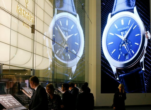 Visitors stand in front of the exhibition stand of Swiss watch manufacturer Patek Philippe