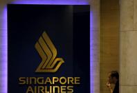 FILE PHOTO: A man looks at a Singapore Airlines (SIA) signage outside an SIA service center in Singapore February 10, 2016.