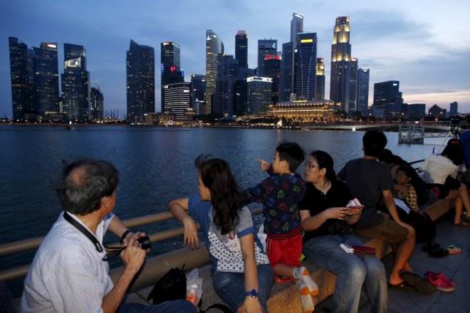 People wait for fireworks during a Golden Jubilee National Day Parade rehearsal along the Marina Bay