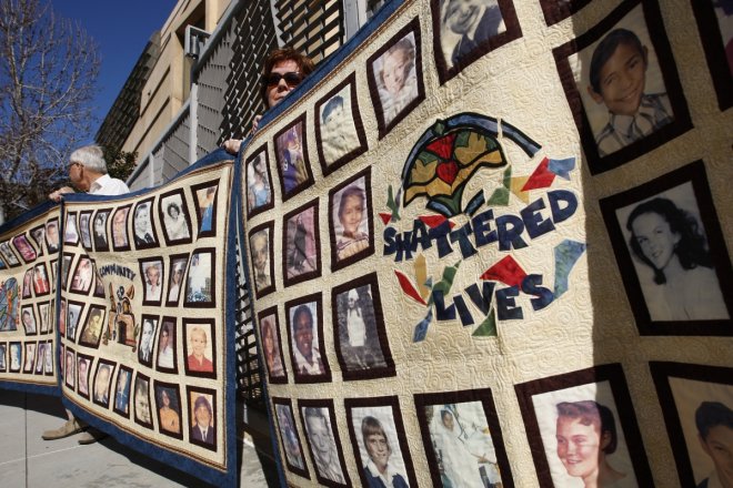 People hold quilts at a press conference outside of Cathedral of Our Lady of the Angels for victims of sexual abuse