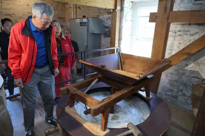 At the historic Peirce Mill. Dried corn drops from the trough in a steady stream into the grindstone to be ground into flour.