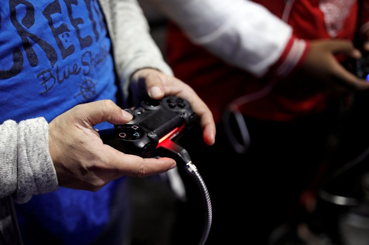 Visitors play games on PlayStation 4 (PS4) at the Paris Games Week, a trade fair for video games in Paris, France, October 26, 2016. REUTERS