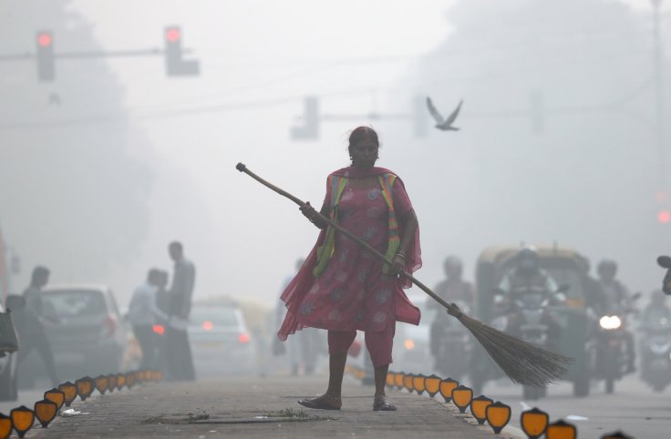 A street cleaner works in heavy smog in Delhi. India plans to use fire trucks to spray water over parts of its capital to combat toxic smog and dust that has triggered a pollution emergency, with conditions expected to worsen over the weekend.