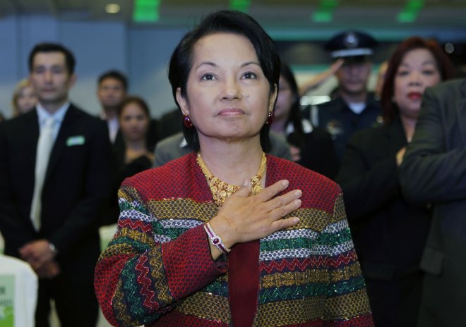 Outgoing Philippine President Gloria Macapagal Arroyo stands on attention