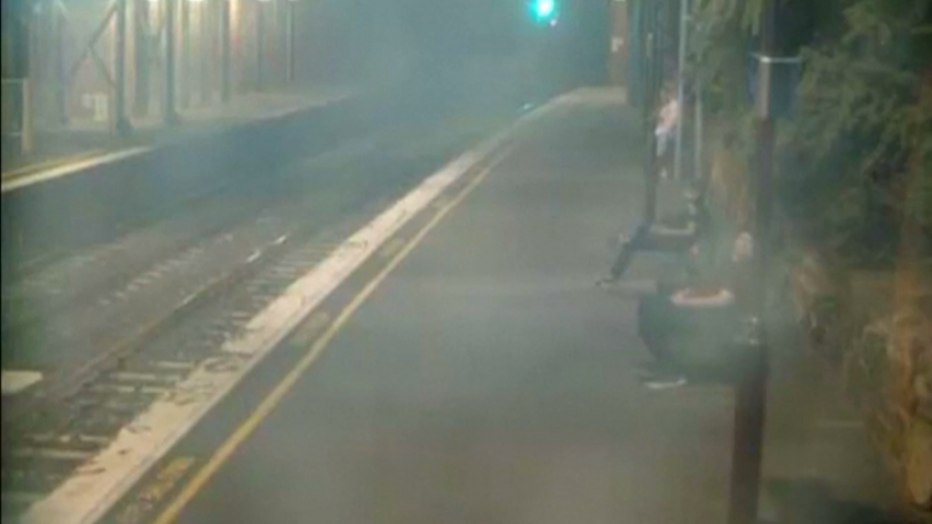 Dramatic footage shows woman pulled away from oncoming train with seconds to spare