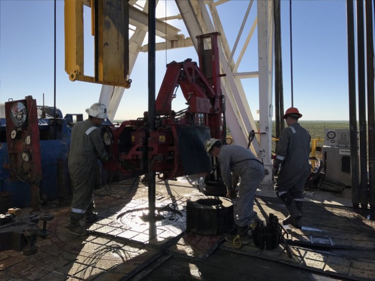 Workers from ScanDrill Ltd clamp together pieces of pipe while drilling an oil well for Jagged Peak Energy Inc near Fort Stockton, Texas.