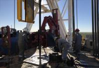 Workers from ScanDrill Ltd clamp together pieces of pipe while drilling an oil well for Jagged Peak Energy Inc near Fort Stockton, Texas.
