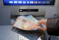A woman withdraws money from an ATM machine in Nice