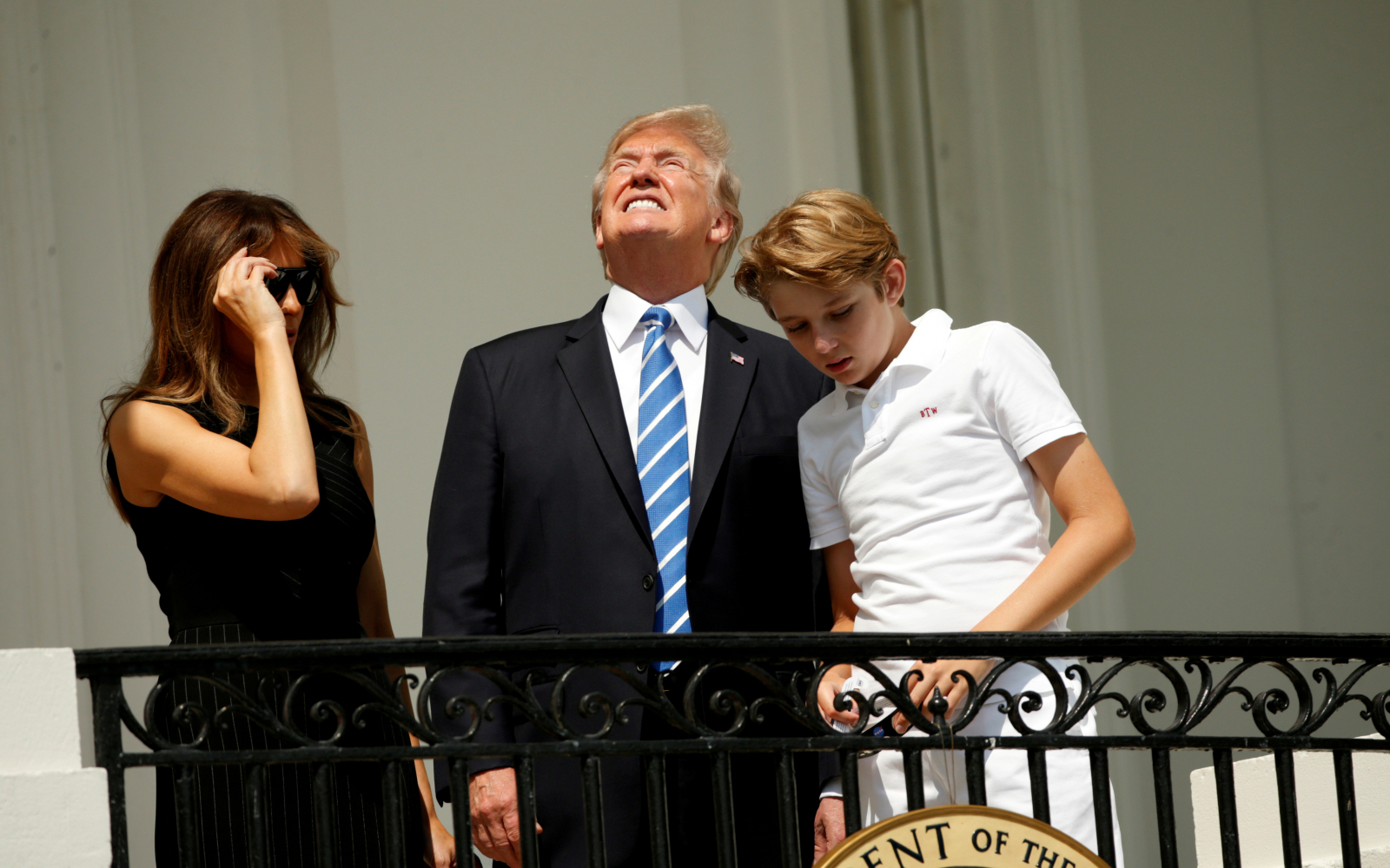 President Donald Trump looks up towards the solar eclipse while viewing with first lady Melania and son Barron 