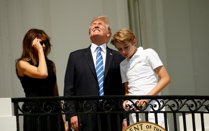 President Donald Trump looks up towards the solar eclipse while viewing with first lady Melania and son Barron 