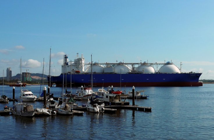 An LNG tanker passes boats along the coast of Singapore