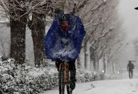 A man rides a bicycle in the heavy snow in Tokyo
