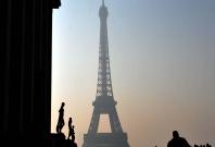 People walk near the Eiffel tower in haze in Paris, capital of France