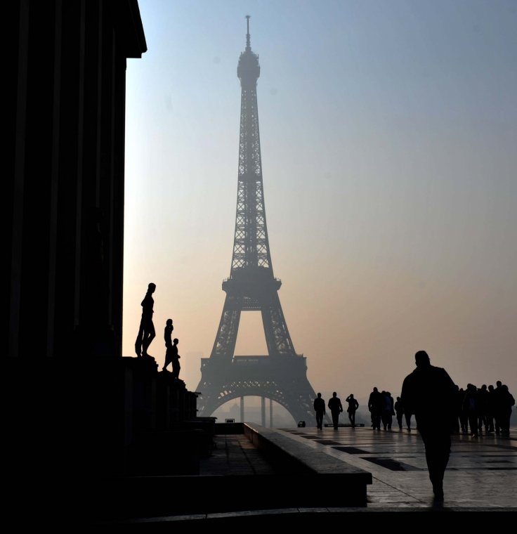 People walk near the Eiffel tower in haze in Paris, capital of France