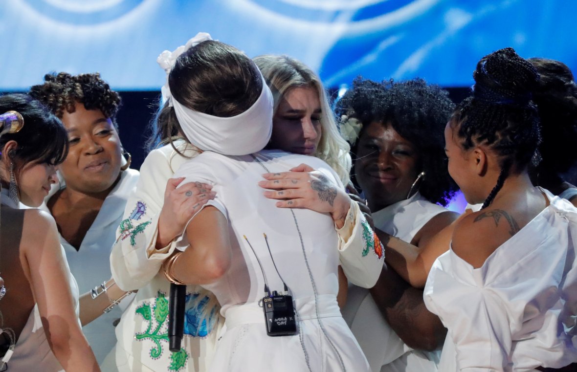 Kesha (rear, C) is embraced by a multitude of singers after they performed 