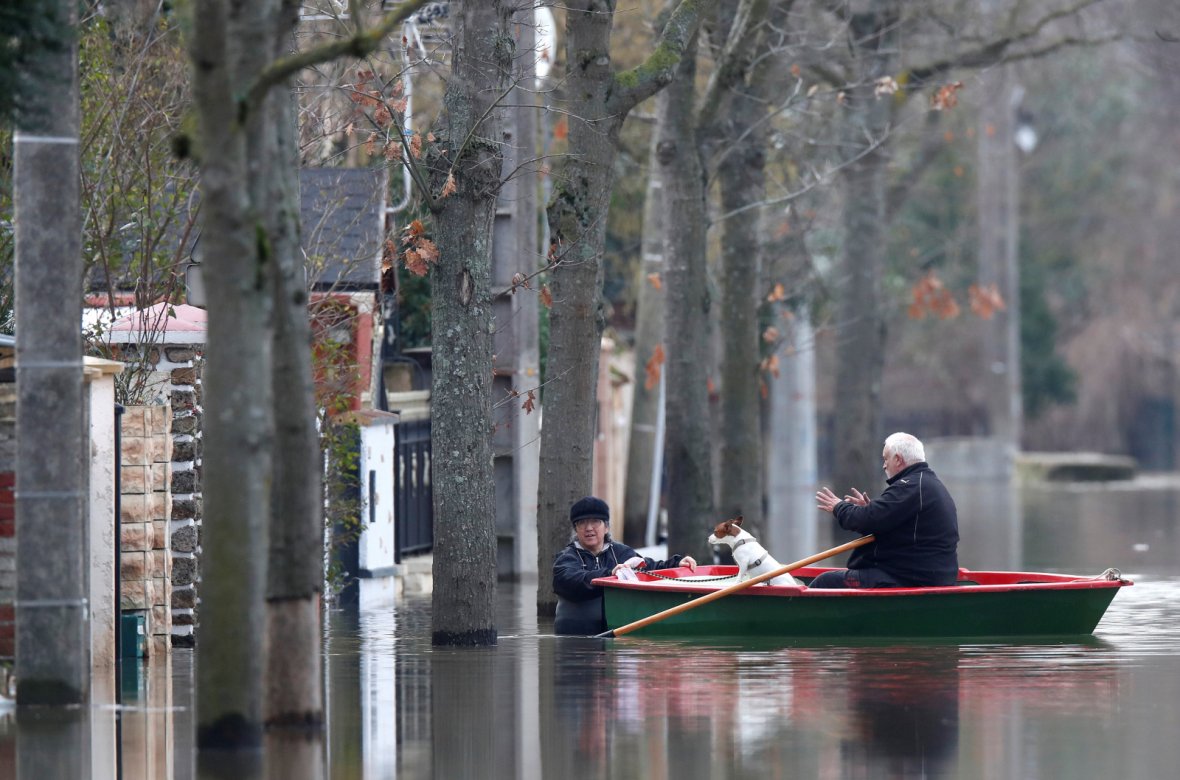 Residents on a small boat leave home in a flooded street of Villeneuve-Saint-Georges
