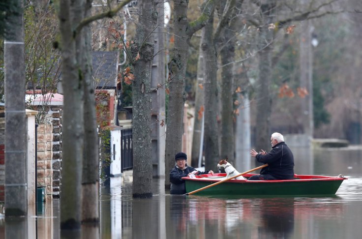Residents on a small boat leave home in a flooded street of Villeneuve-Saint-Georges