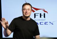 SpaceX founder Elon Musk waves at a press conference following the first launch of a SpaceX Falcon Heavy rocket at the Kennedy Space Center