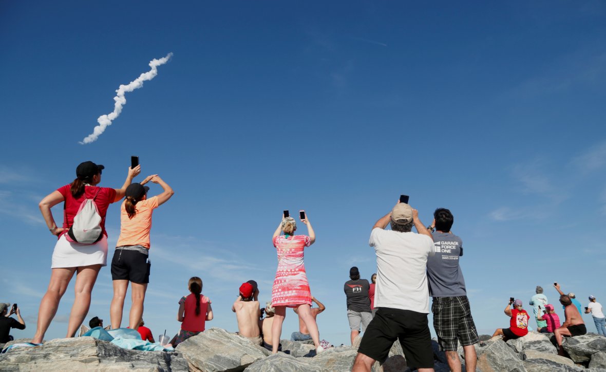 Spectators watch SpaceX's first Falcon Heavy rocket launches from the Kennedy Space Center in Florida
