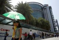Office workers pass a Singpost office under construction in Singapore Office workers pass a Singpost office under construction in Singapore