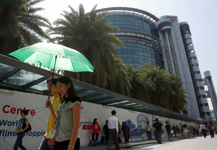 Office workers pass a Singpost office under construction in Singapore