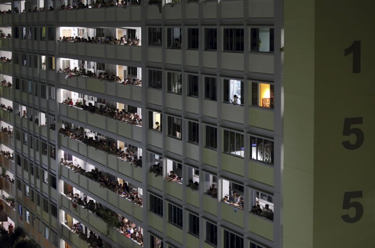 Residents and people crowd the corridors of a public housing estate 