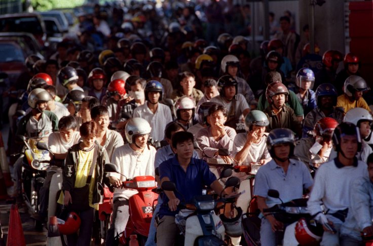 Malaysian motorcyclists wait to go through customs at the Malaysia - Singapore border