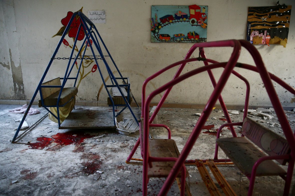 Blood stains the ground under swings in a damaged kindergarten after an air strike in the rebel-held besieged city of Harasta, in the eastern Damascus suburb of Ghouta, Syria