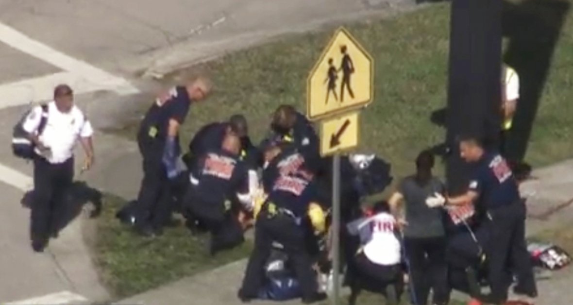 Rescue workers deal with a victim near Marjory Stoneman Douglas High School during a shooting incident in Parkland, Florida