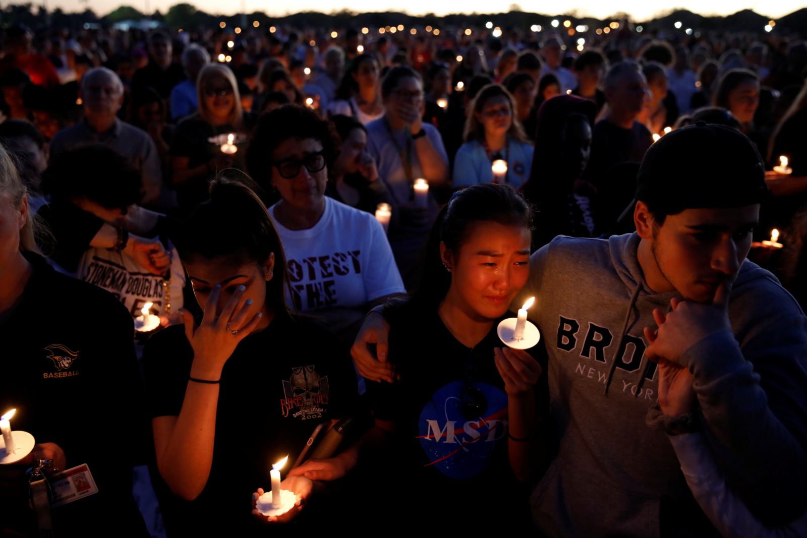 People attend a candlelight vigil for victims of the shooting at nearby Marjory Stoneman Douglas High School, in Parkland, Florida