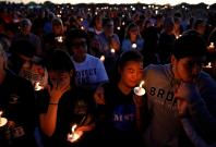People attend a candlelight vigil for victims of the shooting at nearby Marjory Stoneman Douglas High School, in Parkland, Florida