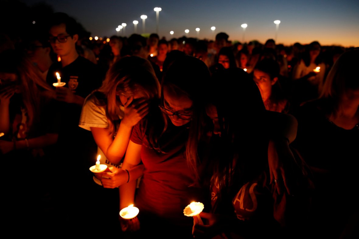 People attend a candlelight vigil for victims of the shooting at nearby Marjory Stoneman Douglas High School