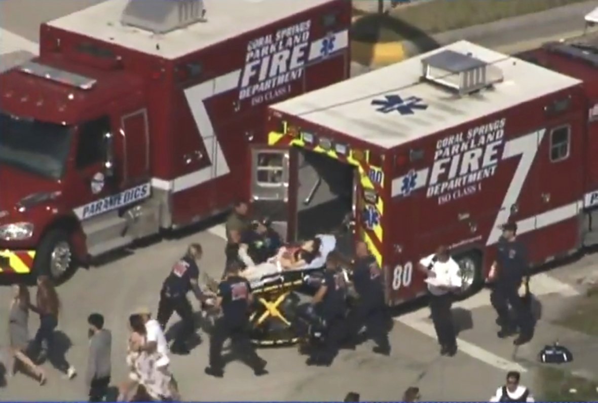 Rescue workers prepare to transport a victim on a stretcher near Marjory Stoneman Douglas High School
