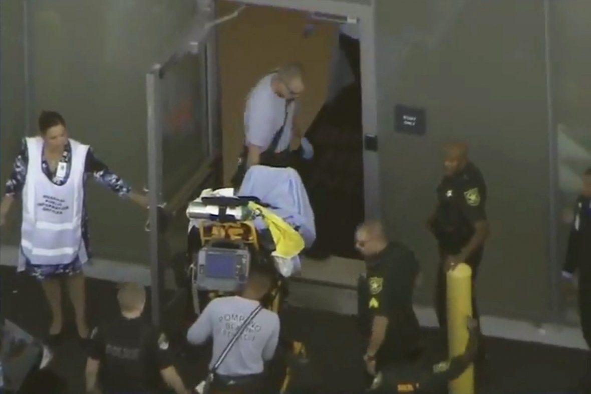 A man placed in handcuffs by police is wheeled on a stretcher into a hospital near Marjory Stoneman Douglas